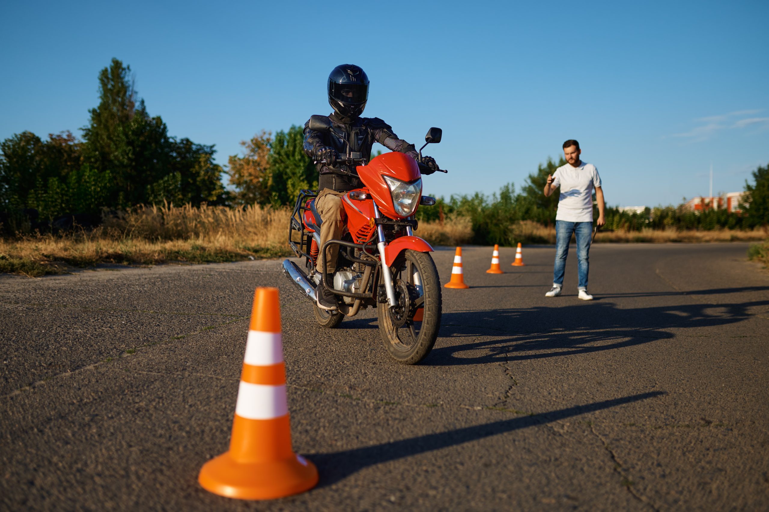 Male student in helmet and instructor, skill exam in motorcycle school. Training of motorcyclists beginners, biker practicing in motorschool